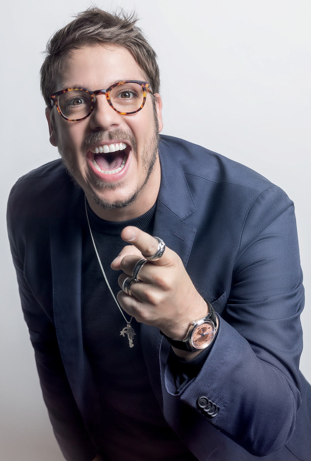 Homem Alegre de Óculos Aponta, Rindo com Entusiasmo