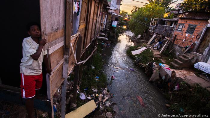 Criança em favela ribeirinha: pobreza e poluição
