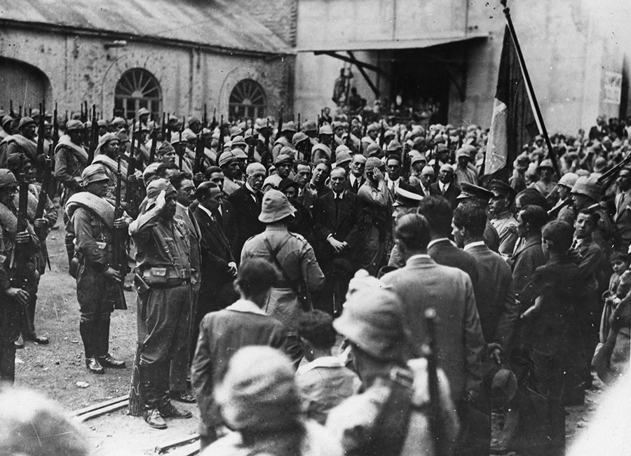 Multidão, militares e figuras políticas em evento histórico