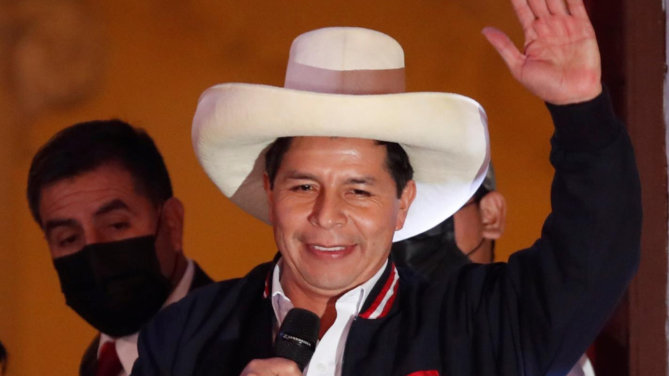 Pedro Castillo acena em evento político com microfone.