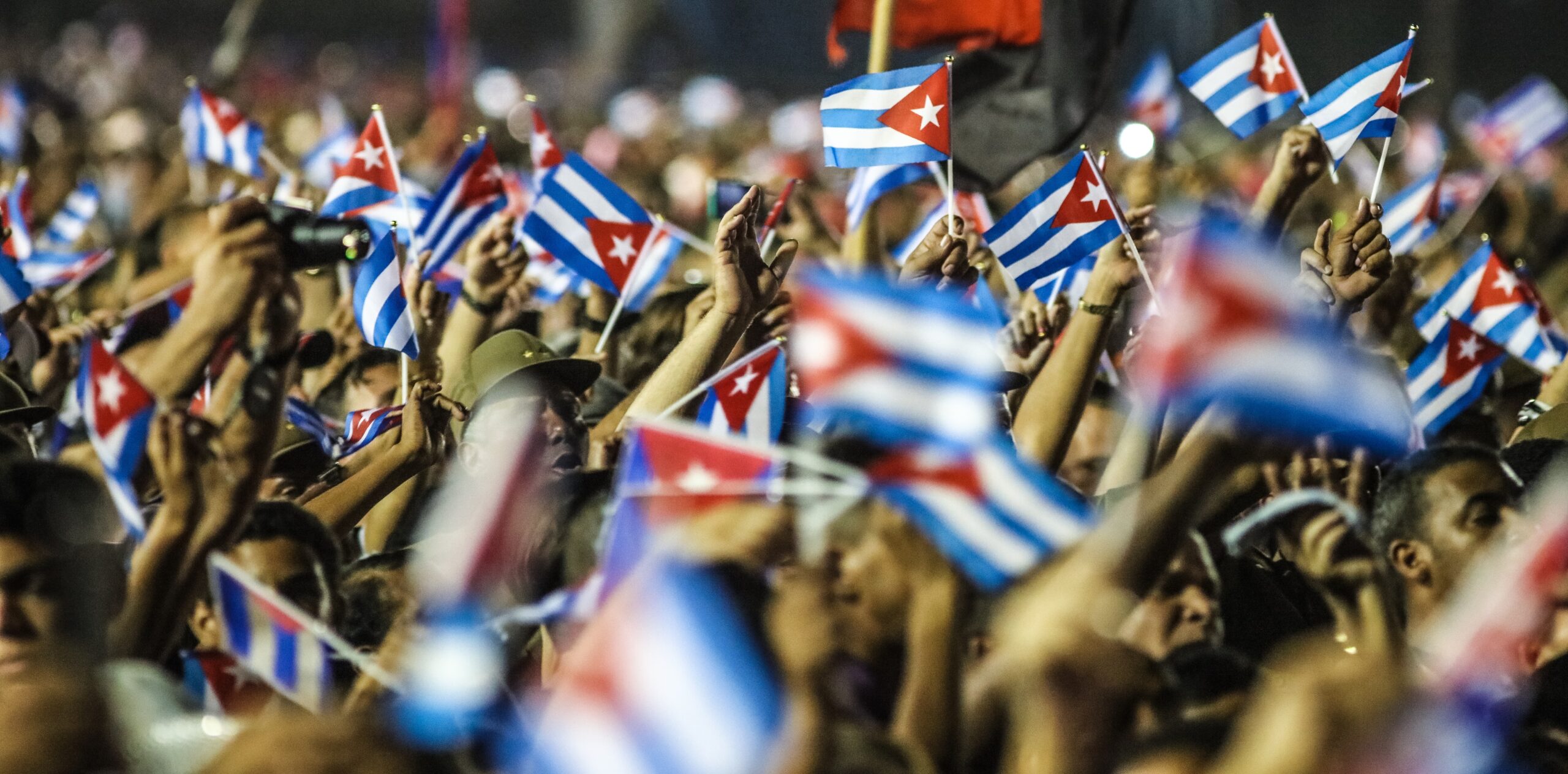 Multidão Cubana Manifesta Unidade com Bandeiras à Noite