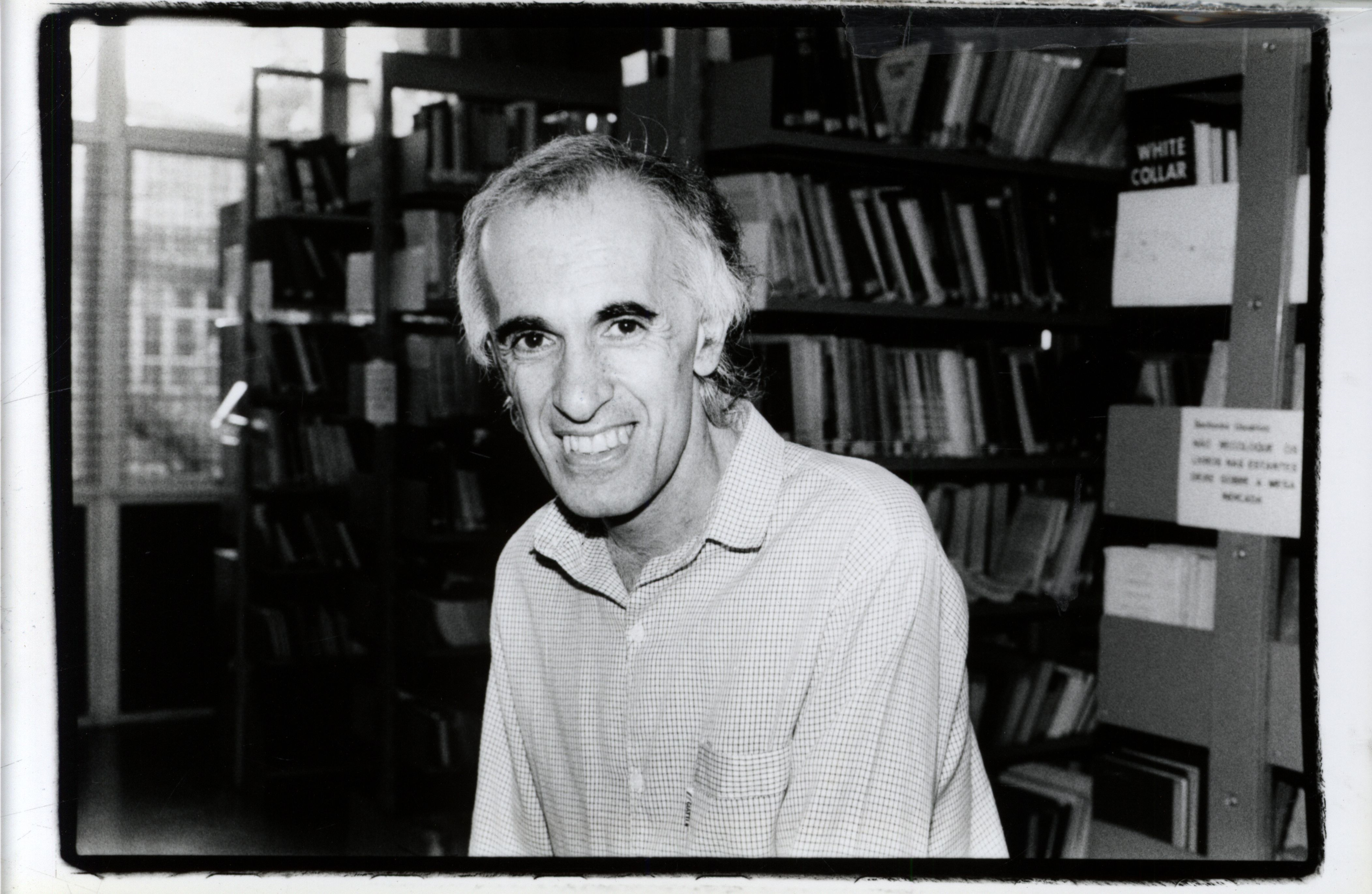 Intelectual Sorridente em Biblioteca: Reflexão e Conhecimento