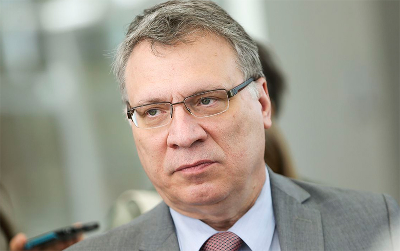 Homem de óculos e terno com expressão séria