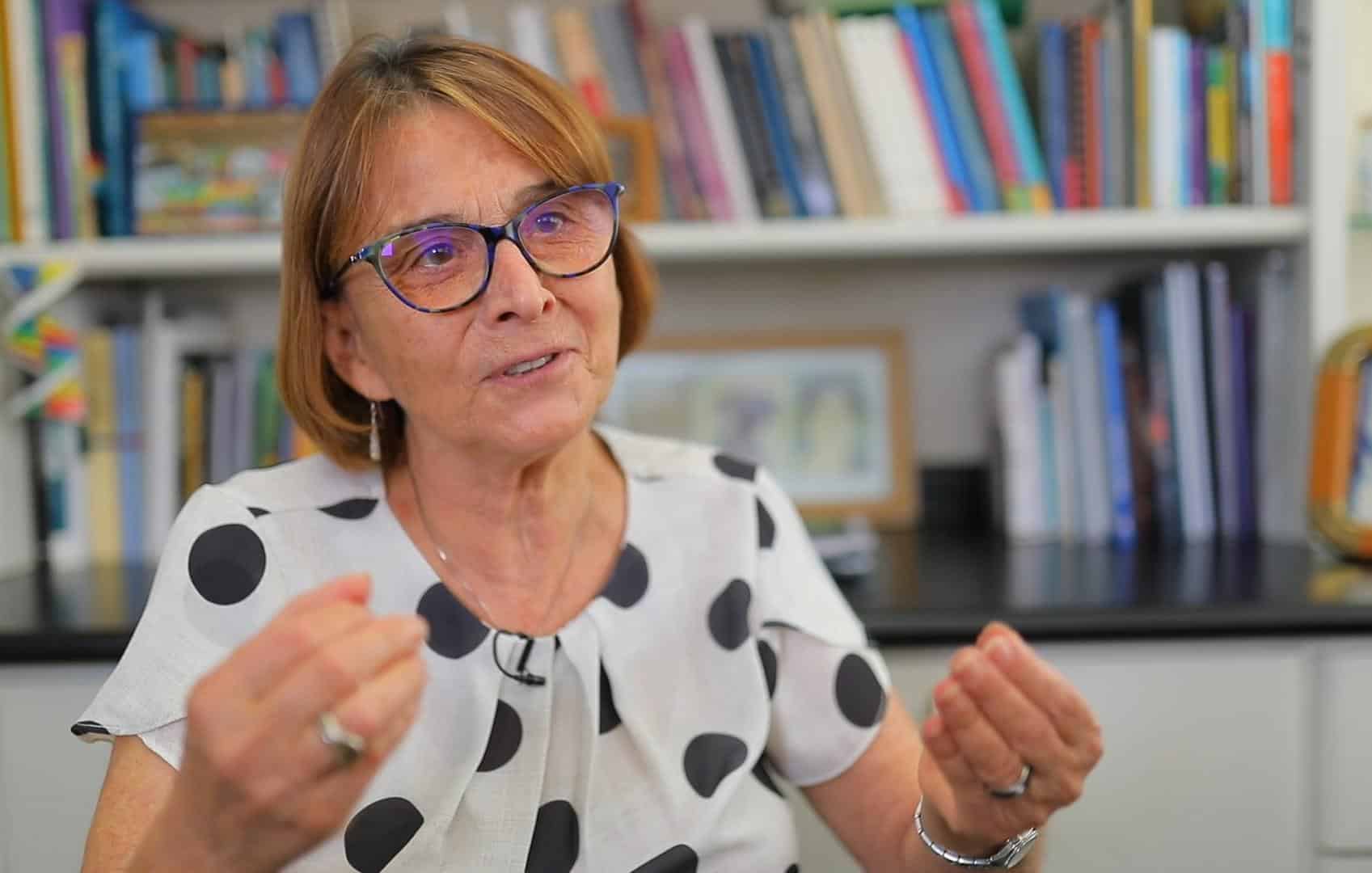 Especialista em diálogo, mulher com óculos em ambiente de livros.