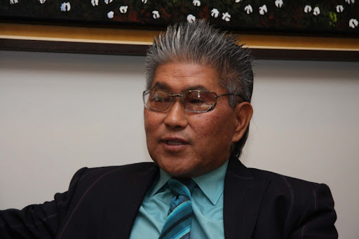 Homem maduro de terno e óculos em conversa