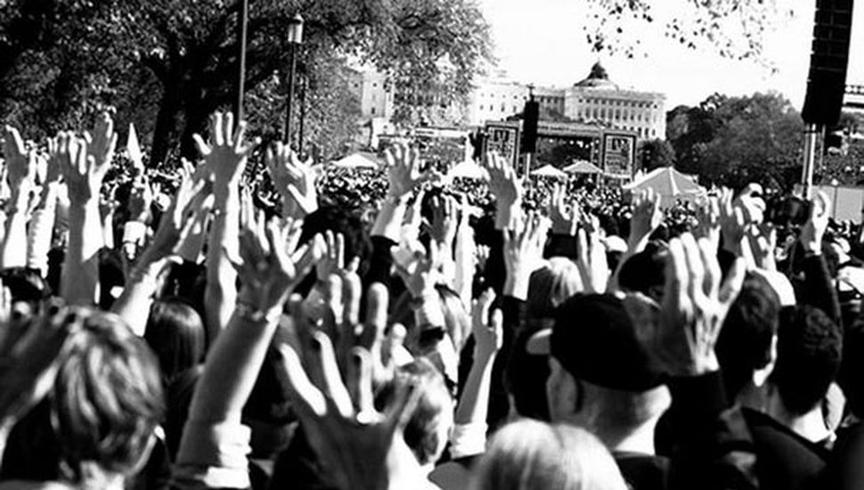 Multidão com Mãos Erguidas em Ato Político