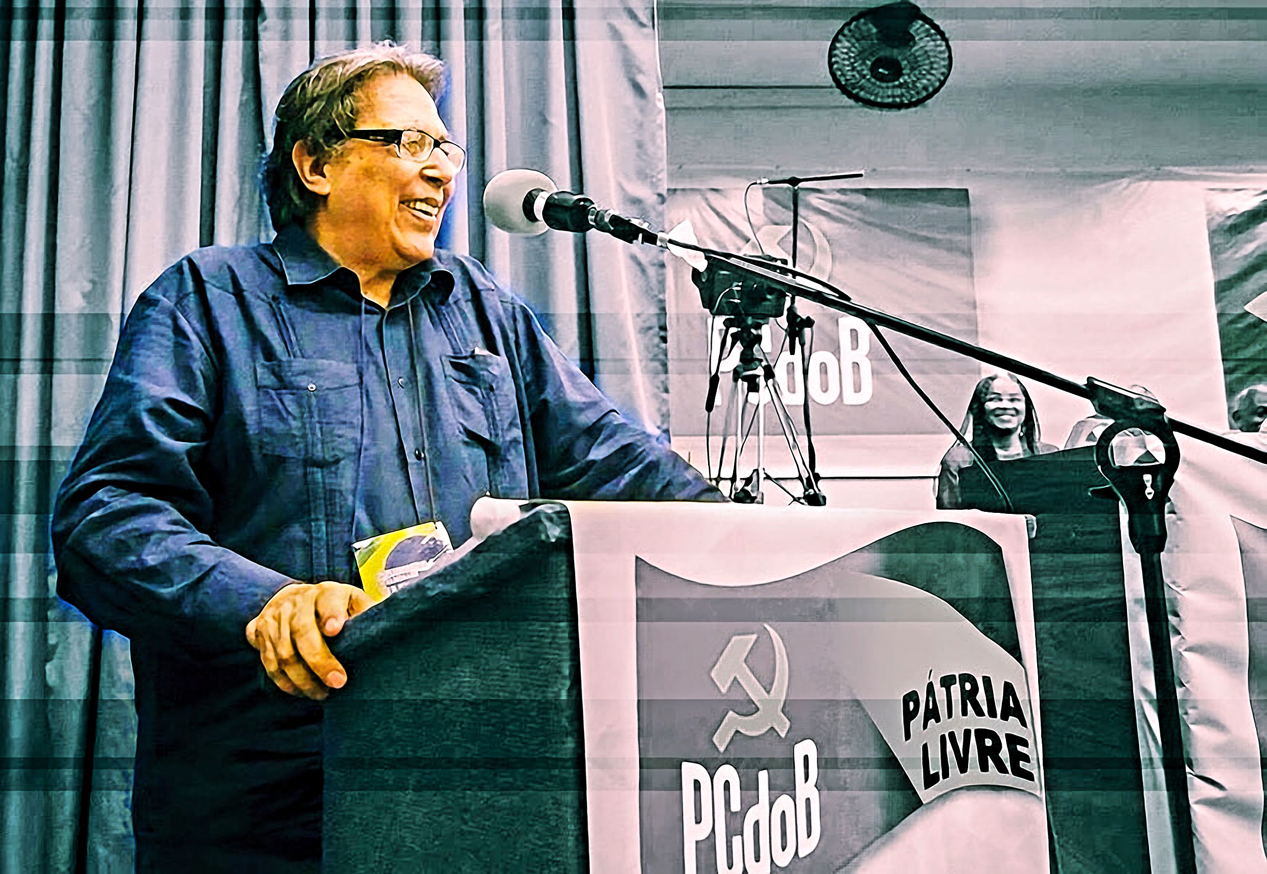 Líder PCdoB discursa em evento político, expressando engajamento.
