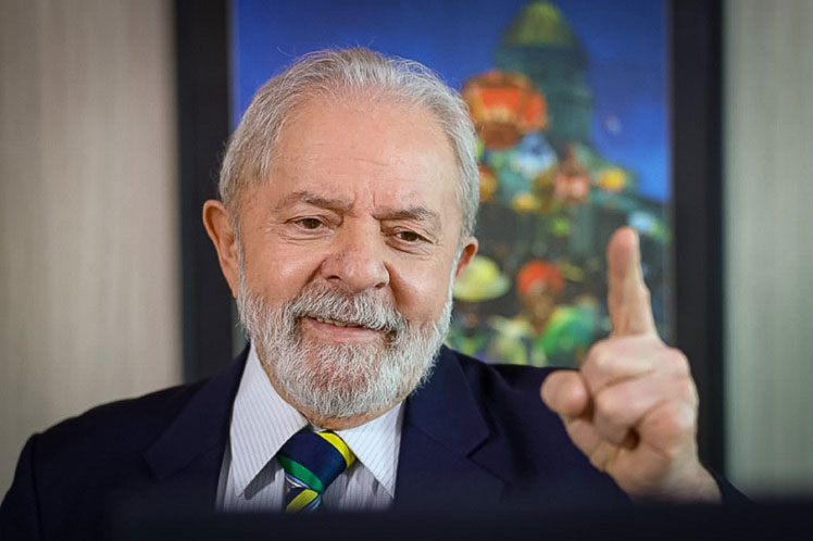 Lula sorridente aponta o dedo, transmitindo confiança