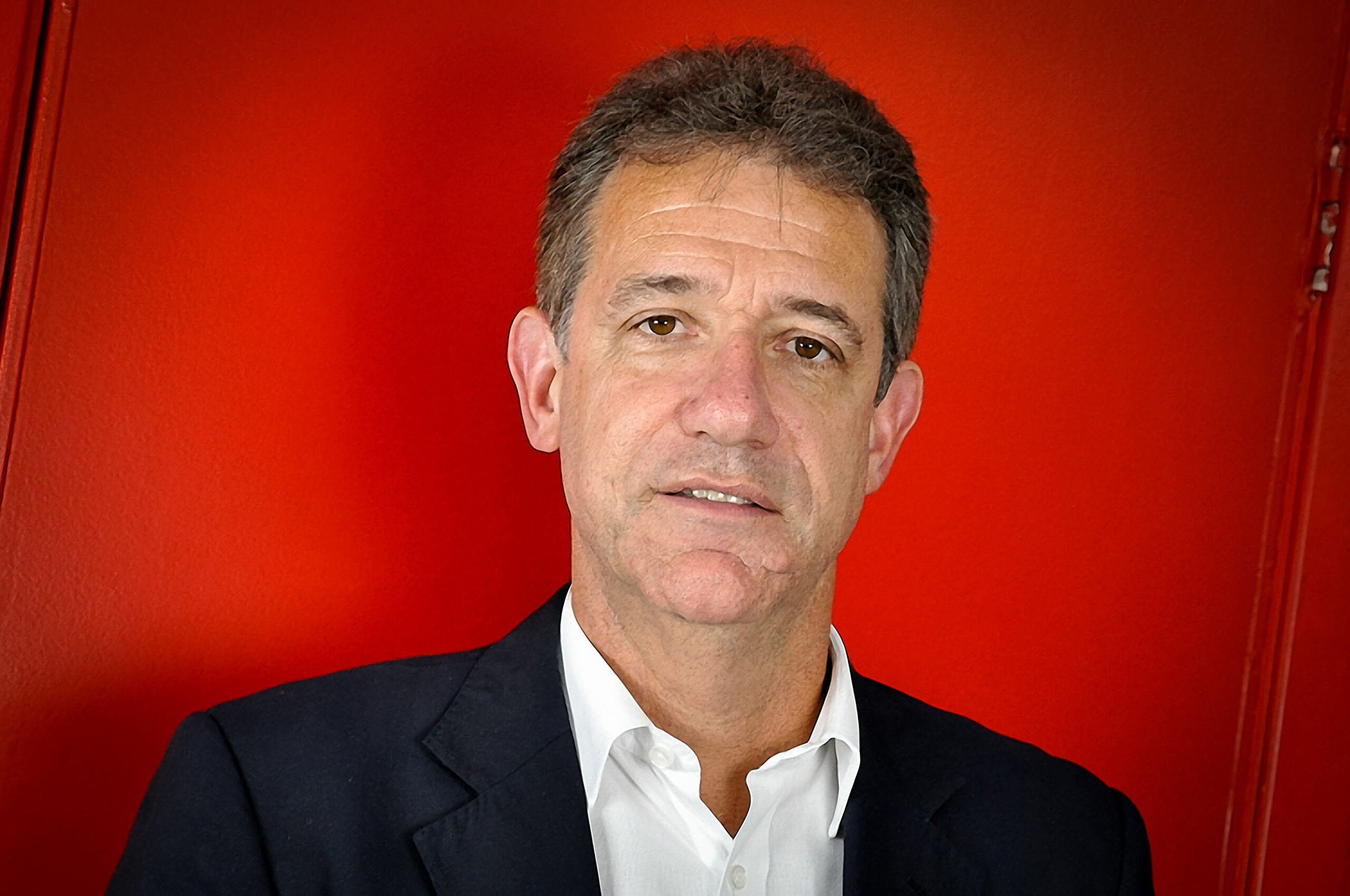 Retrato de homem sério em fundo vermelho vibrante