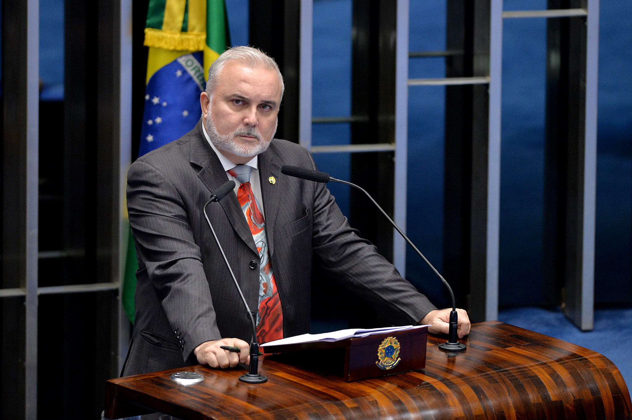 Homem Discursando com Bandeira do Brasil em Tribuna Oficial