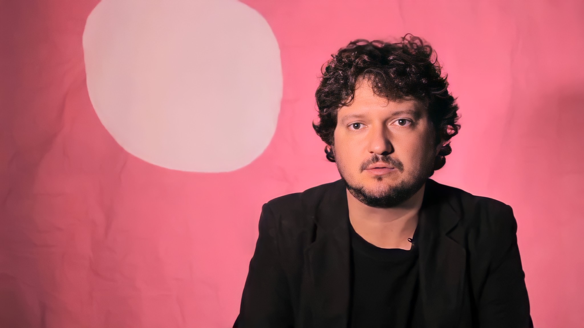 Retrato Masculino: Expressão Séria em Fundo Rosa