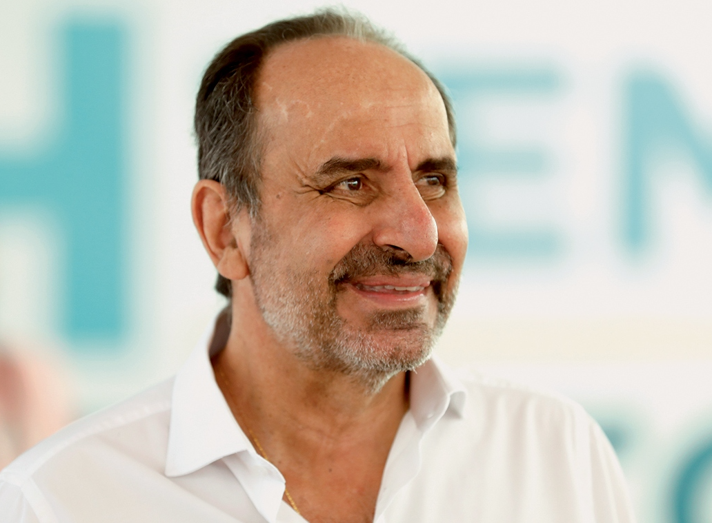 Retrato de homem sorridente e sereno em fundo azul