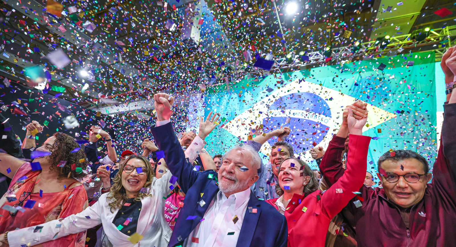 Lula celebra com multidão e confetes sob bandeira brasileira