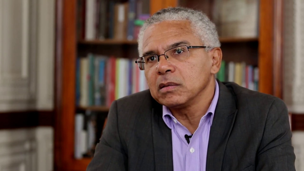 Homem Sênior Pensativo em Ambiente de Biblioteca