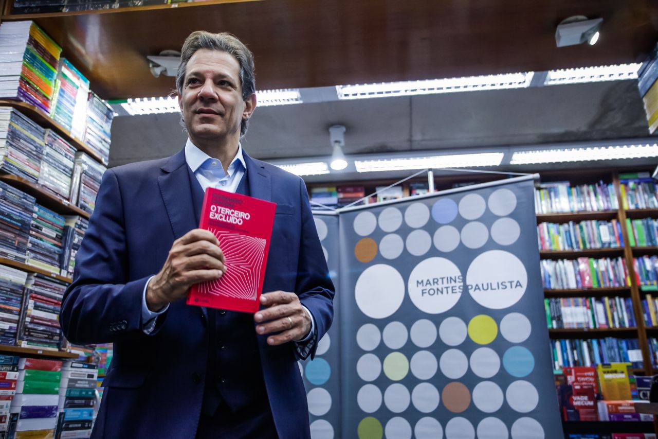 Fernando Haddad com livro "O Terceiro Excluído" em livraria