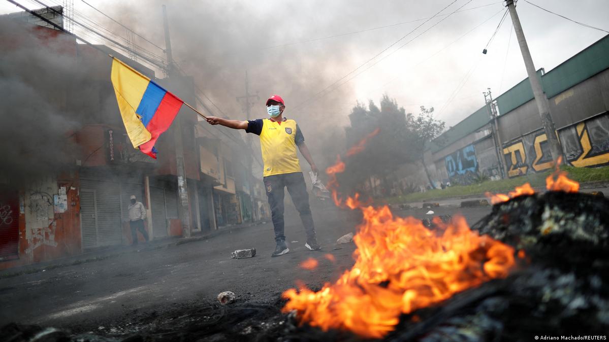 Protesto no Equador: Bandeira, Fumaça e Fogo em Cena Urbana