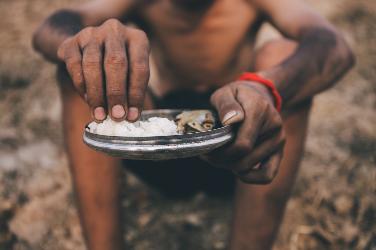 Mãos Cansadas Seguram Refeição Simples em Meio à Pobreza
