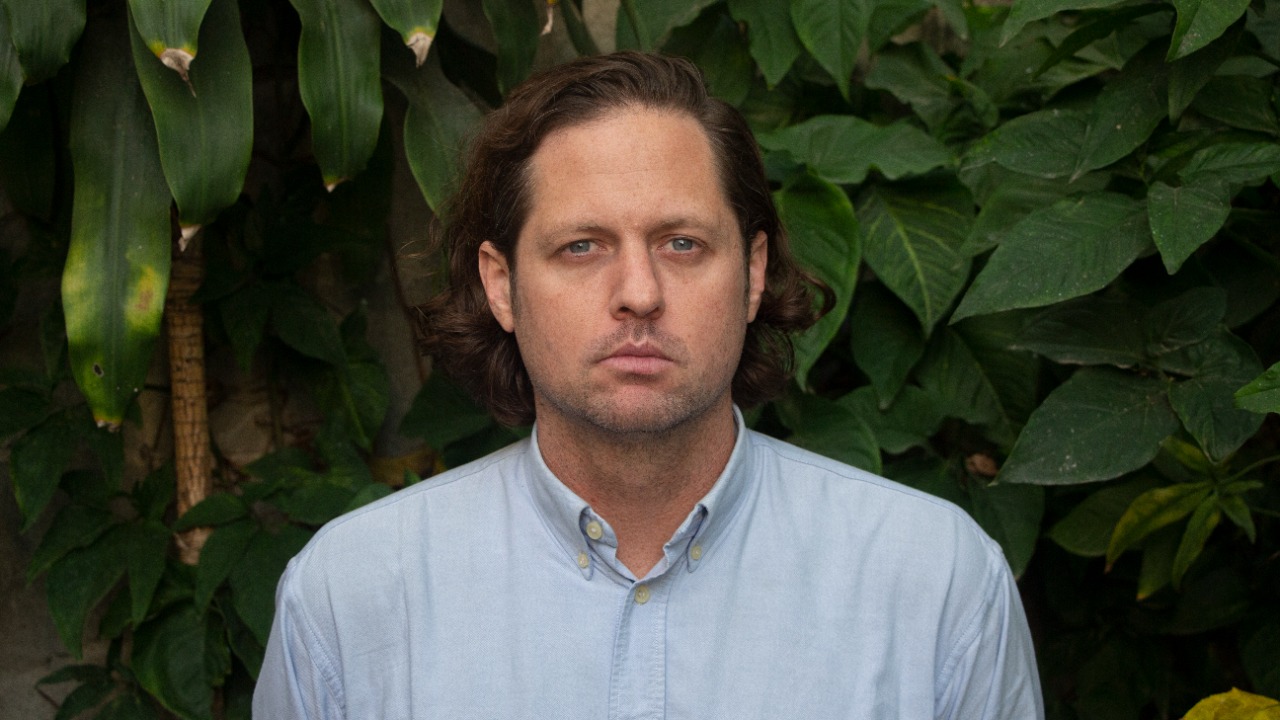 Homem com Olhar Intenso em Fundo Natural