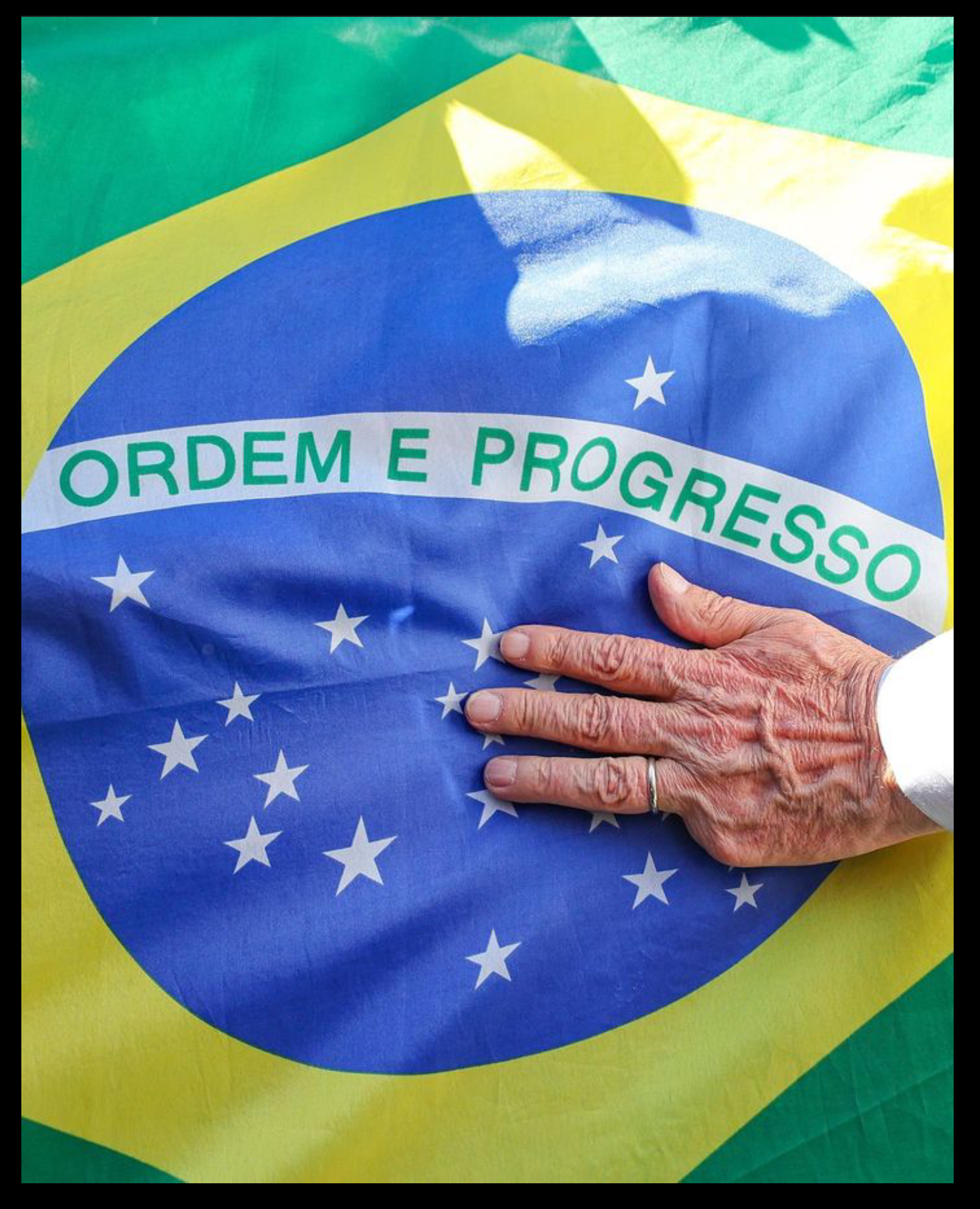Mão sobre Bandeira do Brasil: Ordem e Progresso