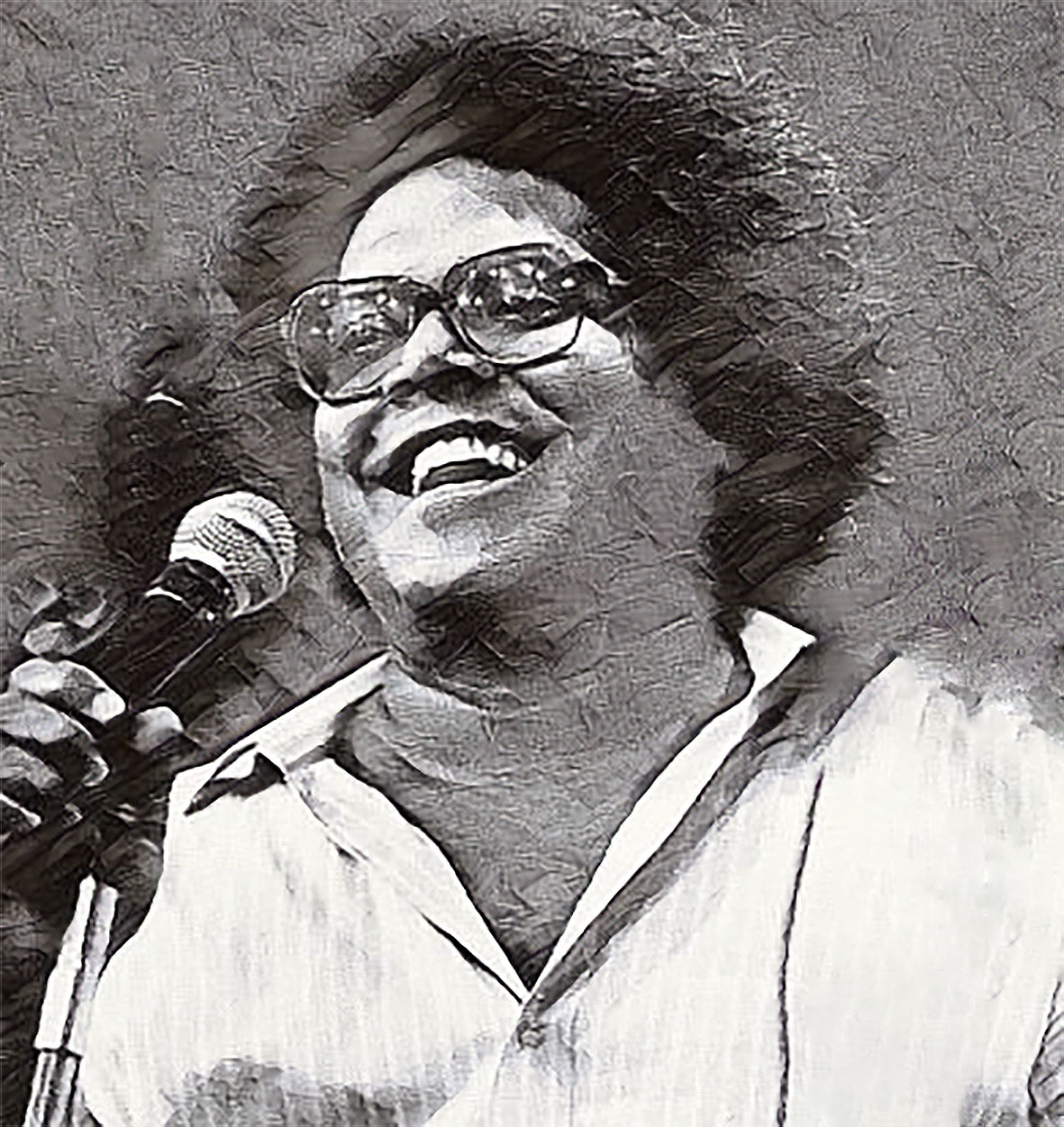 Artista sorridente com microfone, retrato em tons de cinza