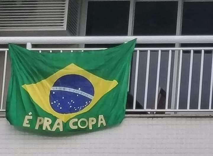 Bandeira do Brasil na sacada com "É PRA COPA"