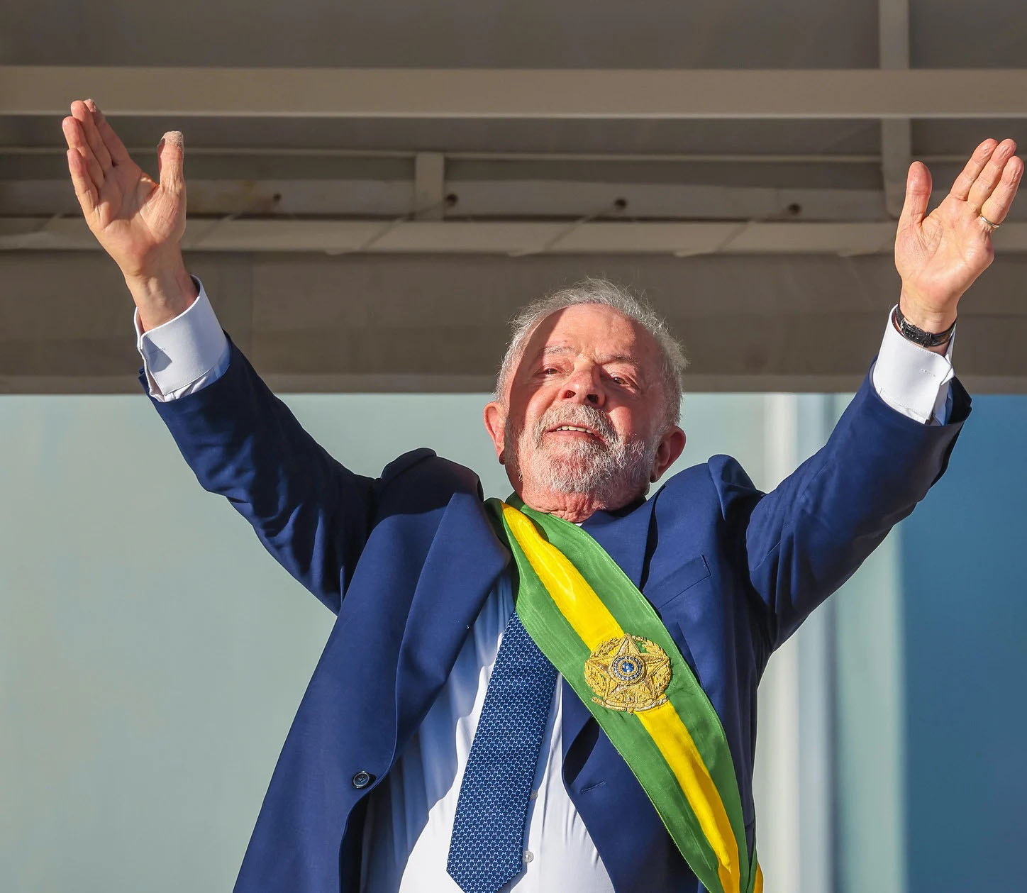 Lula presidente celebra com braços erguidos e faixa presidencial