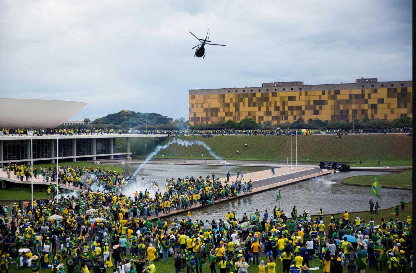 Grande protesto em Brasília com helicóptero e fumaça.