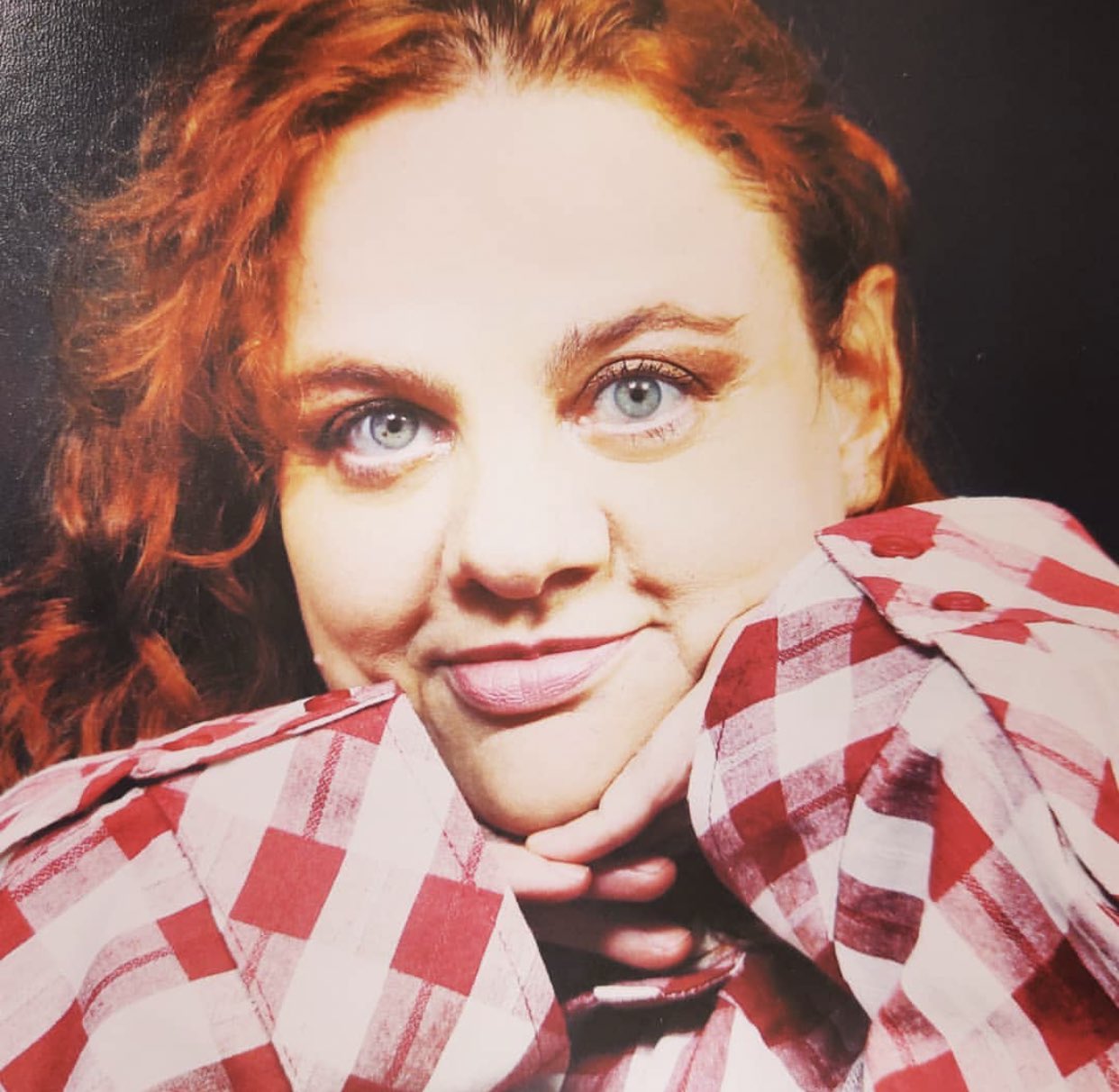 Retrato acolhedor: mulher ruiva sorrindo com blusa xadrez