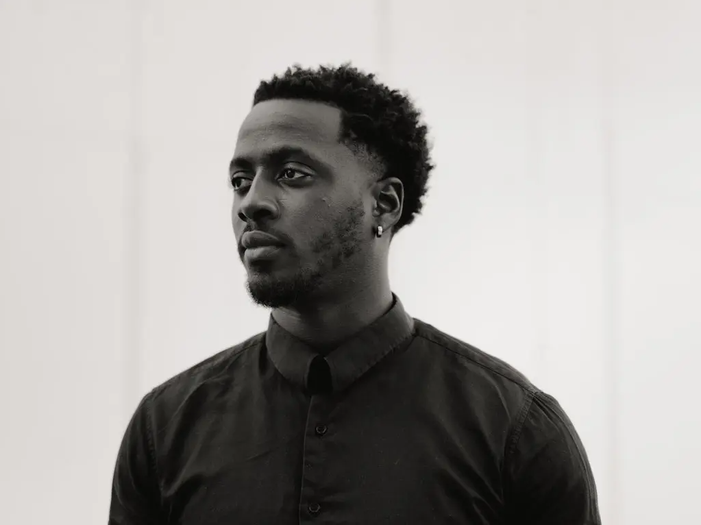 Homem negro em retrato p&b com olhar pensativo