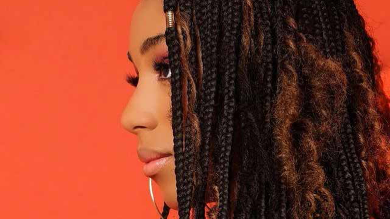 Perfil de Mulher Negra com Tranças em Fundo Laranja