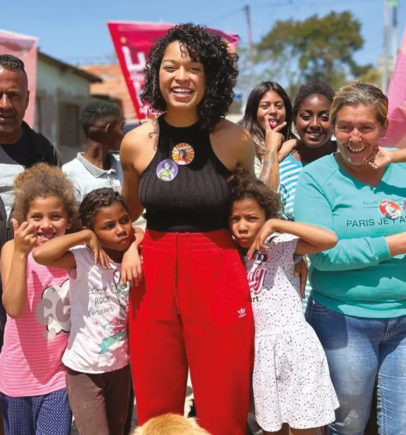 Ativista sorridente com crianças e comunidade vibrante