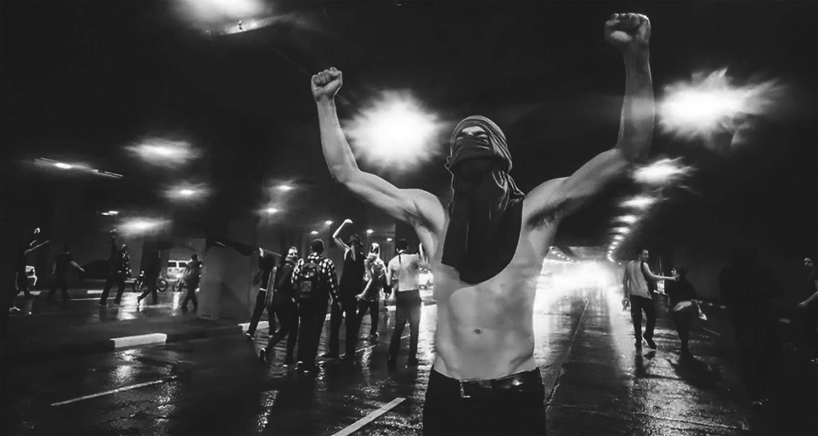 Manifestante em Protesto Noturno: Punhos Erguidos em Ato de Luta