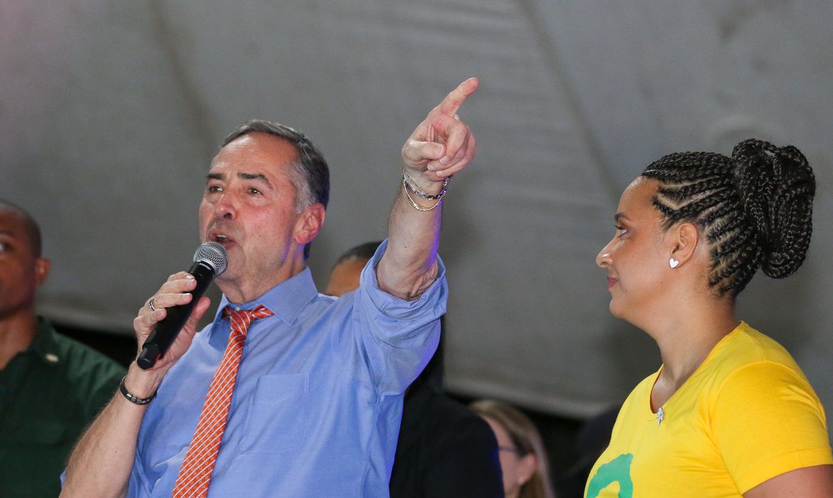 Líder Político Discursa e Mulher Atenta em Evento