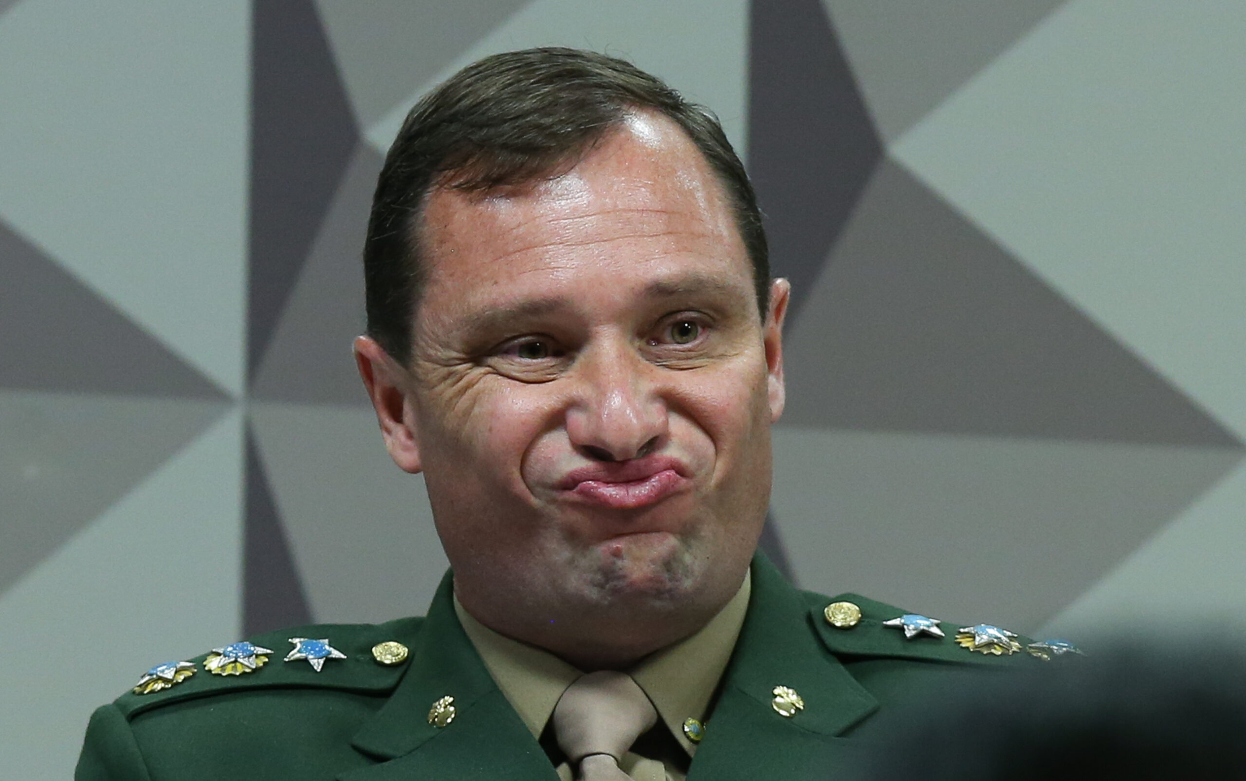 Militar com expressão facial peculiar em evento formal.