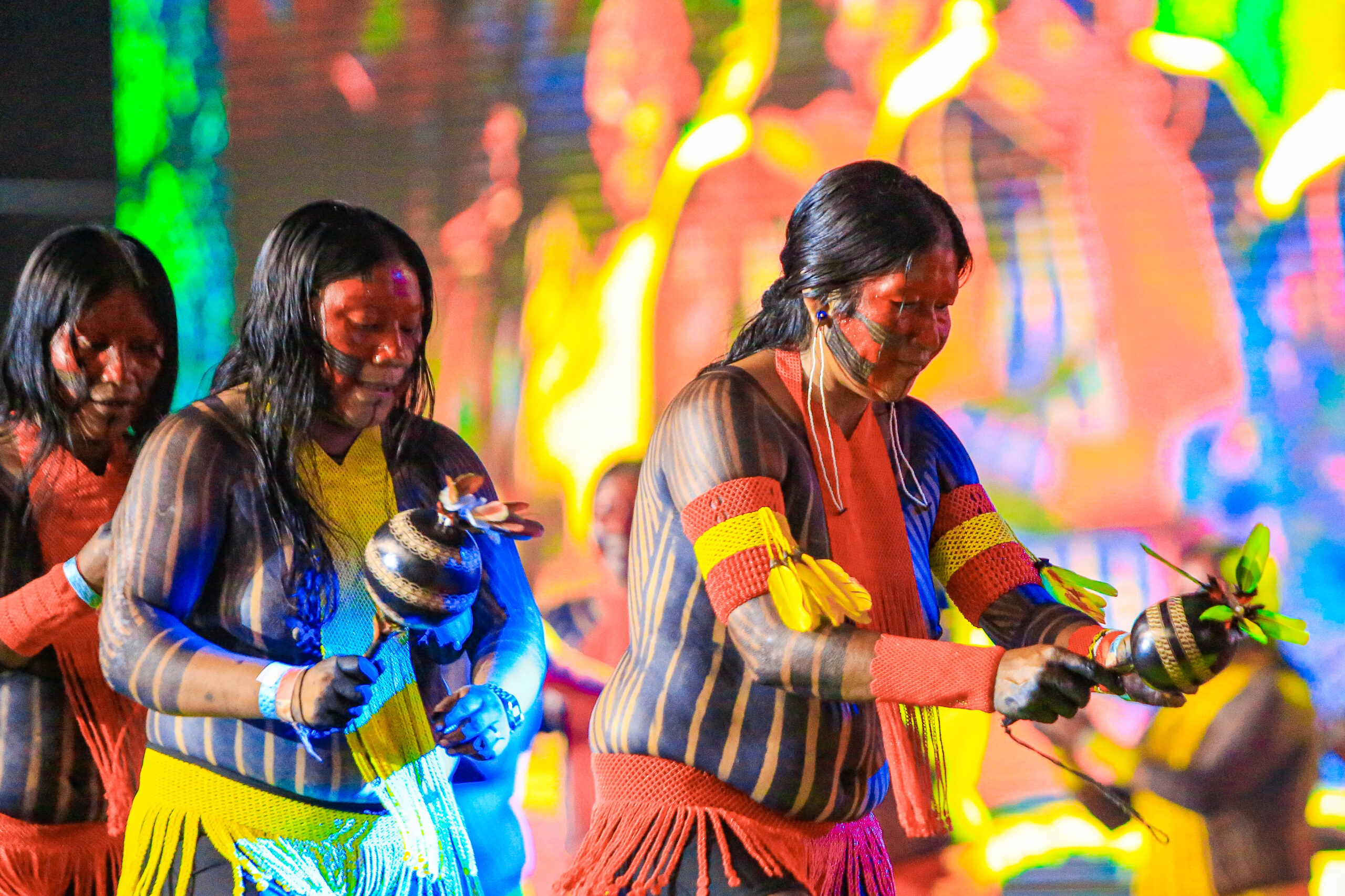 Mulheres Indígenas em Celebração Cultural com Pintura Corporal e Maracás