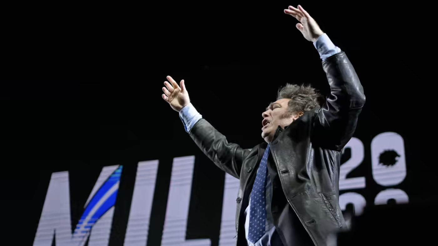 Líder Político Gesticula com Fervor em Palco Escuro