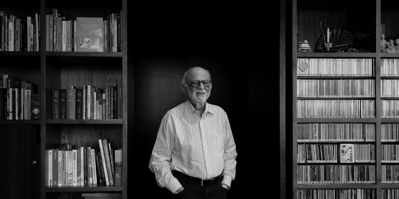 Retrato de Intelectual Sorrindo em Ambiente de Conhecimento e Cultura