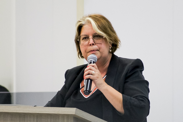 Palestrante Mulher com Microfone em Evento Formal