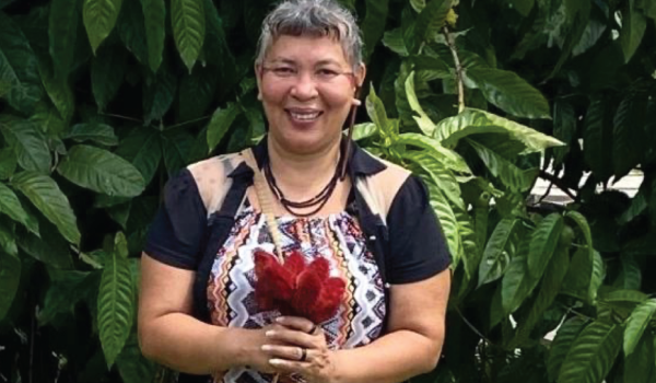 Mulher Sorridente com Elemento Natural em Cenário Verde