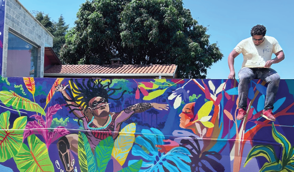 Artista cria mural vibrante: celebração cultural e arte urbana