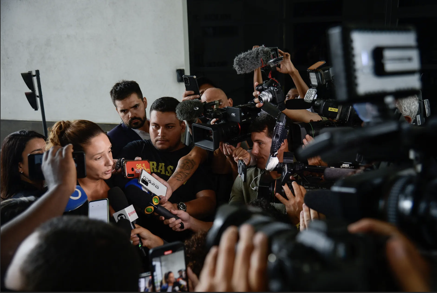 Coletiva de Imprensa: Mulher discursa cercada pela mídia