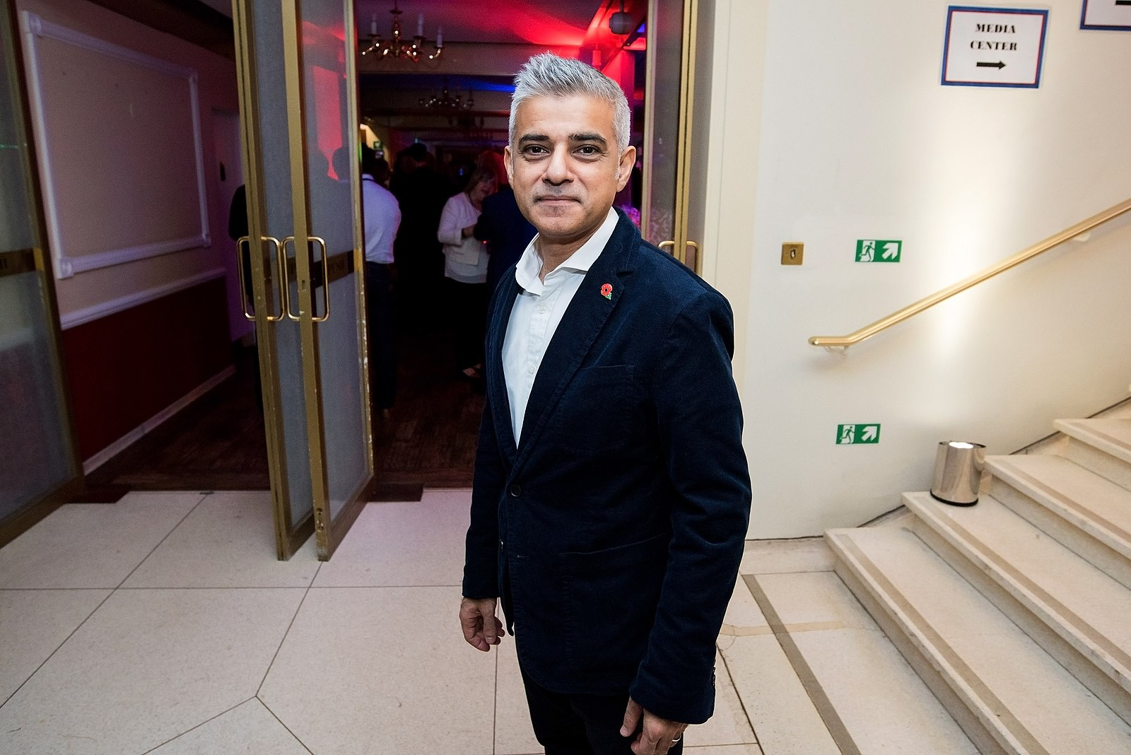 Sadiq Khan em evento, blazer azul e papoula.