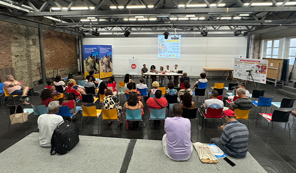 Pessoas assistem a painel de discussão em evento político-social