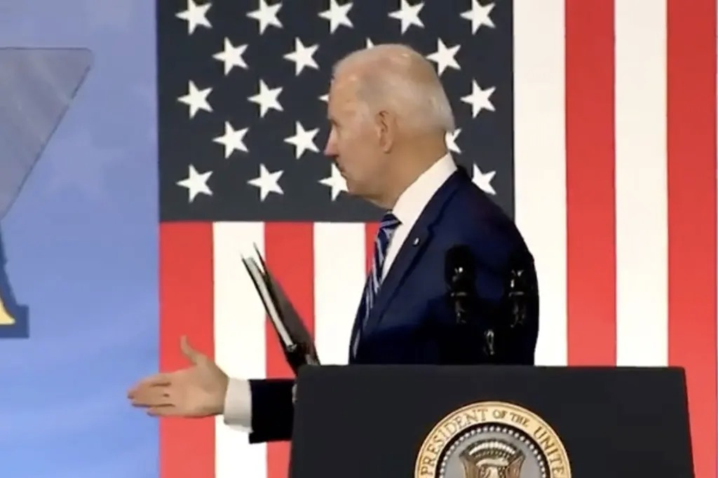 Joe Biden em pódio, com bandeira americana