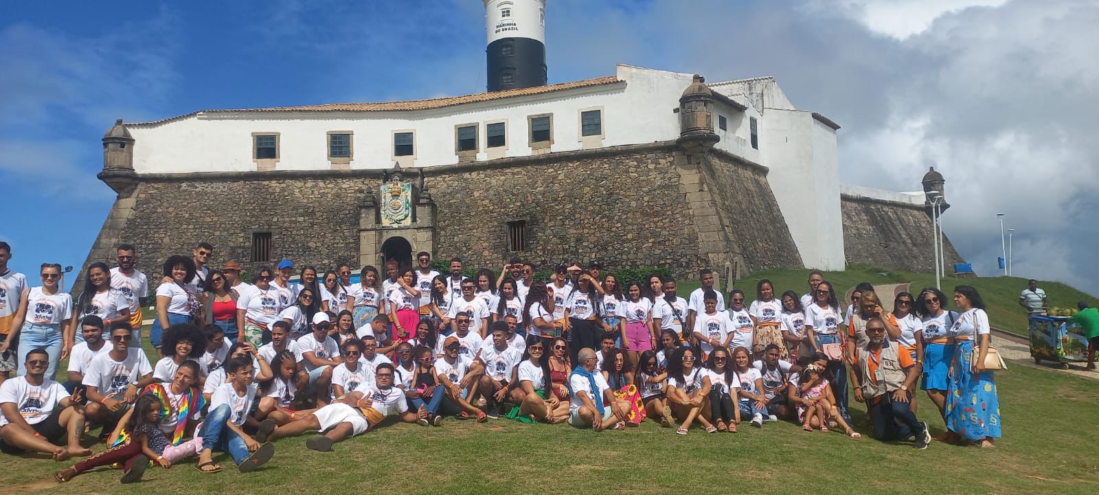 Grupo Diverso em Frente a Forte Histórico e Farol
