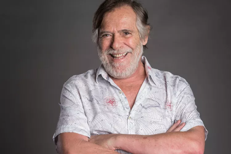 Homem barbudo sorrindo: sabedoria, experiência e otimismo.