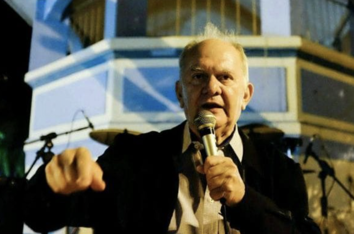 Orador com Microfone e Punho Cerrado Discursando em Evento