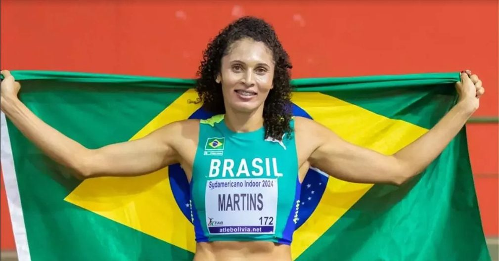 Atleta Martins celebra com bandeira do Brasil no Sudamericano Indoor