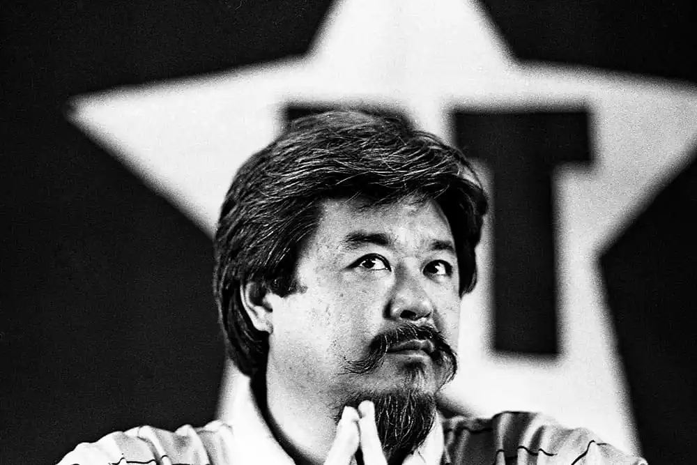 Retrato: Homem asiático pensativo com estrela e 'T' ao fundo