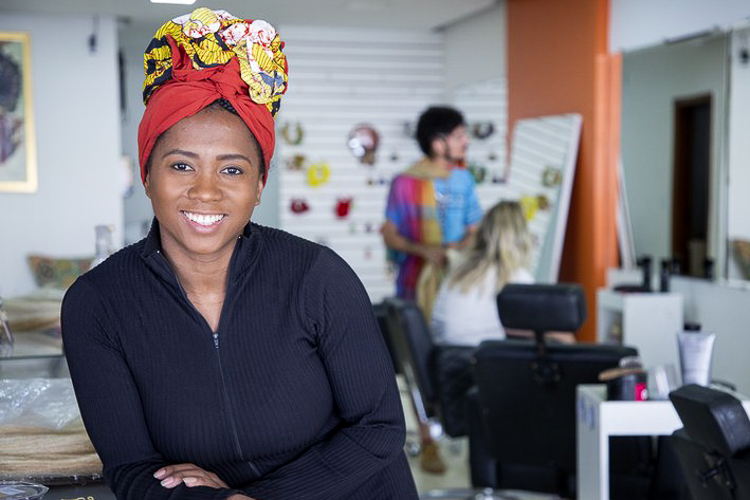 Empreendedora Negra Sorrindo em Seu Negócio de Beleza